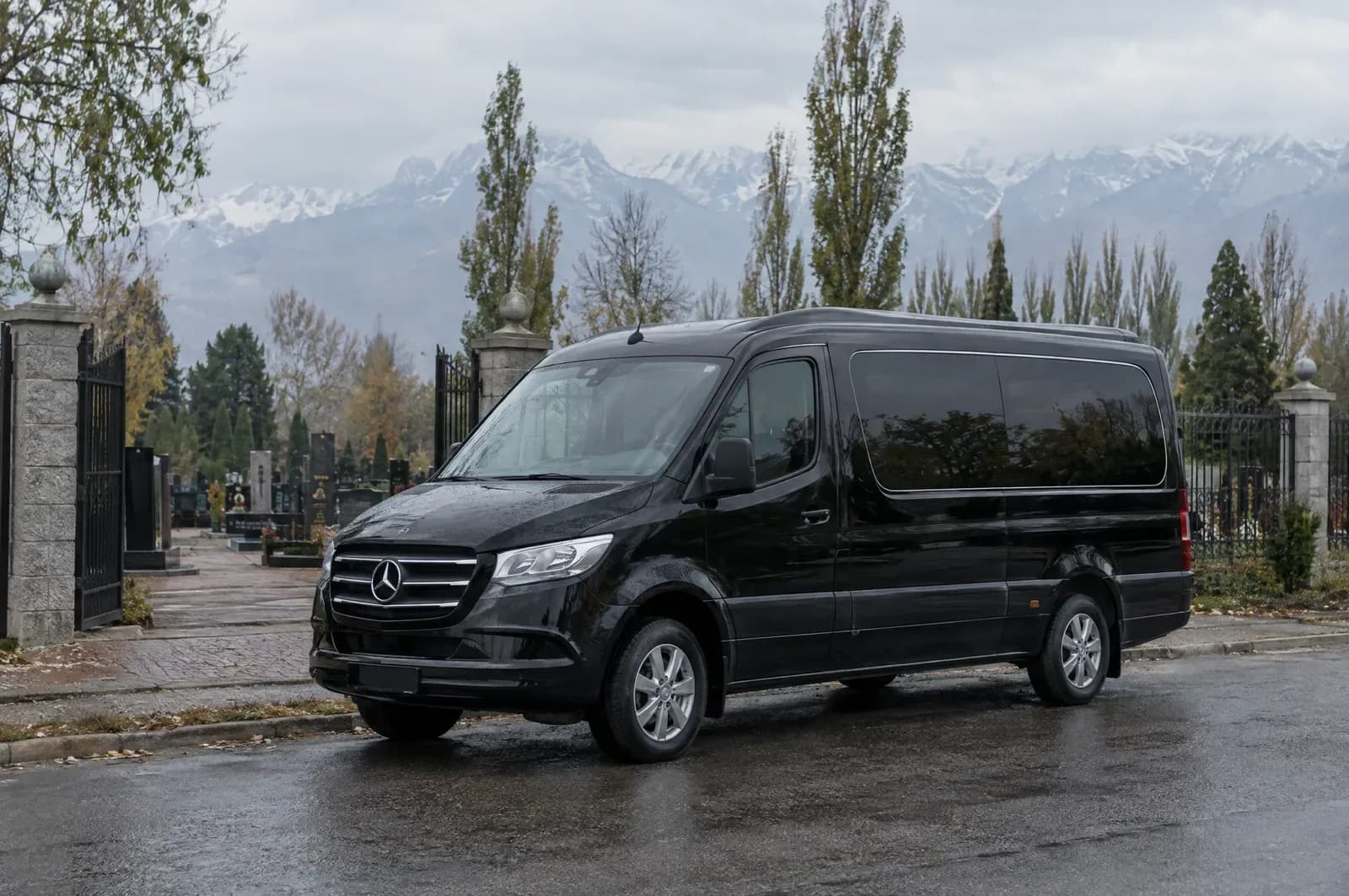 Чёрный катафалк Mercedes Sprinter у ворот кладбища в Алматы