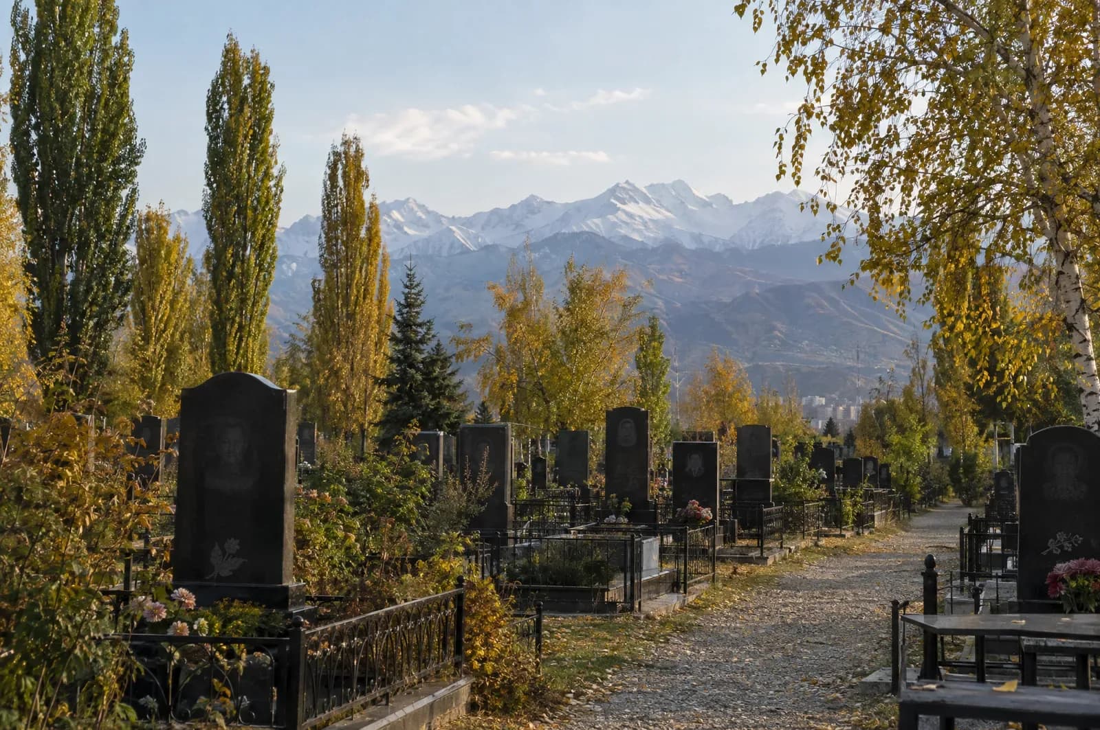 Кладбище в Алматы осенью, гранитные памятники на фоне гор